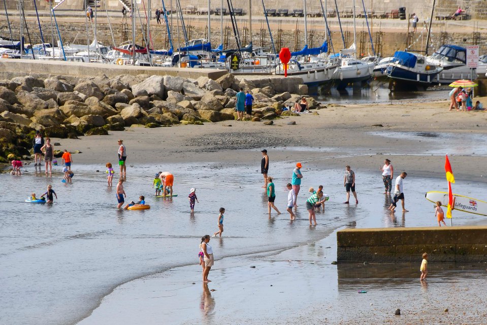 Holidaymakers taking a refreshing dip in the sea at Lyme Regis, Dorset