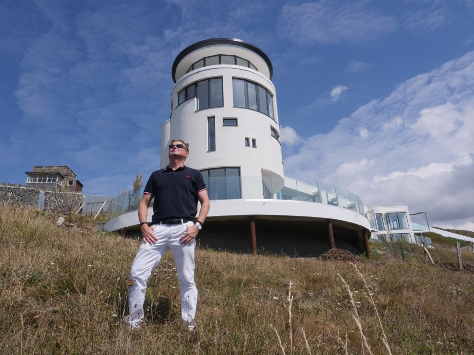 a man stands in front of a white building with the number 11 on it