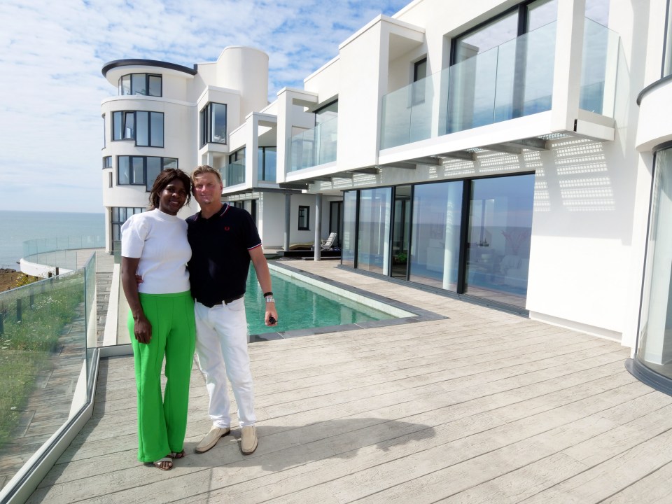 a man and woman standing in front of a large white building