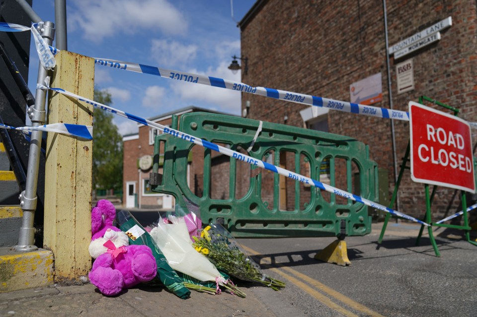 A pink soft toy was left among tributes by the police cordon this morning