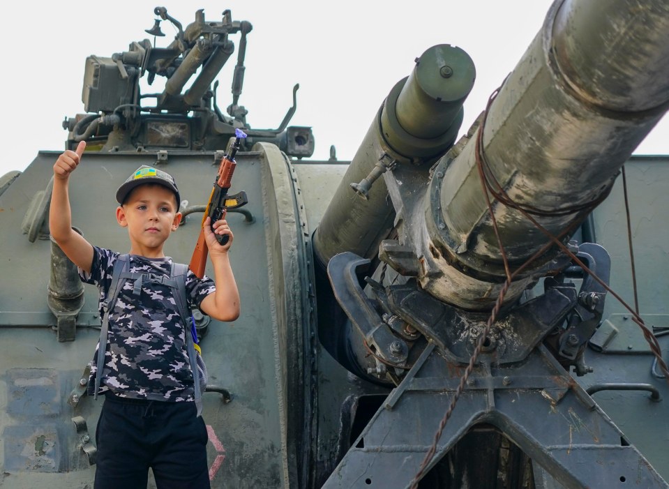 Schoolboy Lev Morilyi gripped his toy AK-47 on a destroyed Russian tank yesterday as he declared: 'We will defeat Putin'