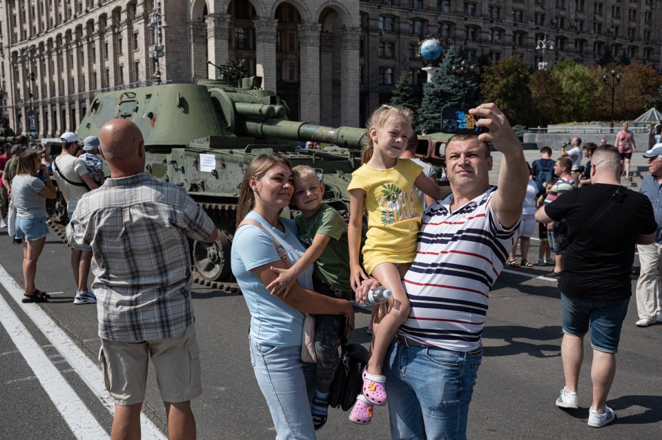 A family takes a selfie by the destroyer Russian weapons