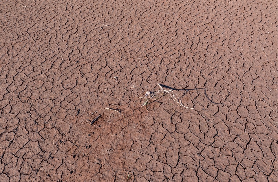 Dried and cracked mud is exposed as an ongoing heat wave causes low water levels at Pontsticill Reservoir near Merthyr Tydfil, England