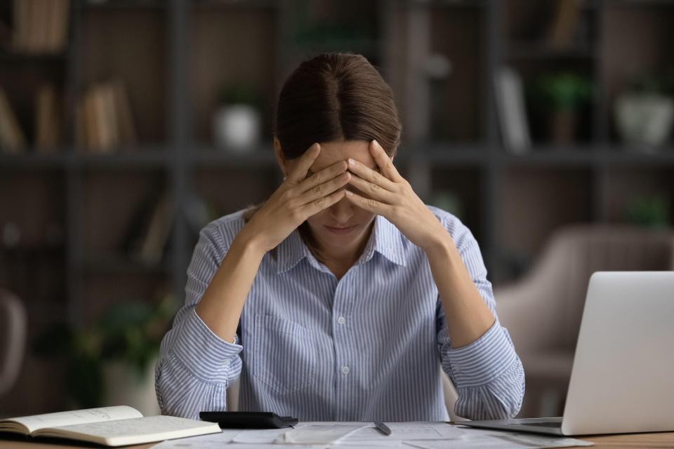 2GG65H4 Depressed woman calculating bills, sitting at desk, financial problems