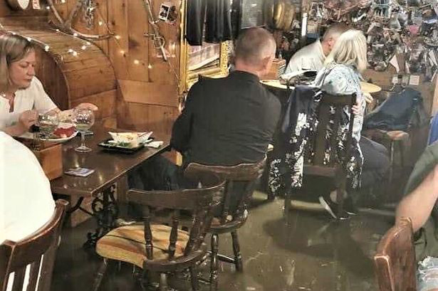 Pics shows how groups casually chow down as water engulfs their feet