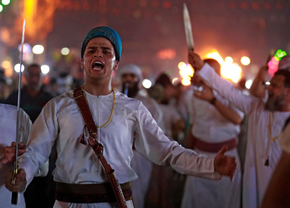 Shiite Muslims raise their swords and knives during the Tatbir processions in Baghdad