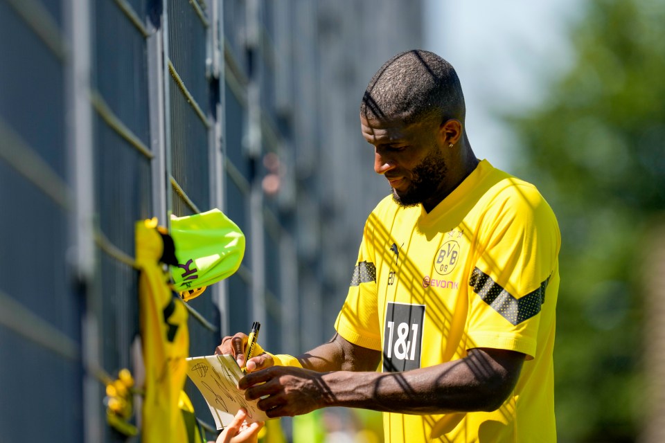 Modeste writes autographs for fans at Dortmund's training ground