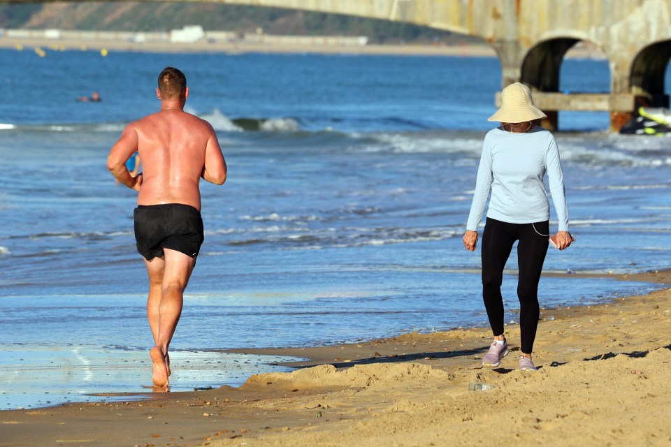 A shoeless jogger hits Bournemouth Beach for an early morning run on the shore in Dorset on Wednesday