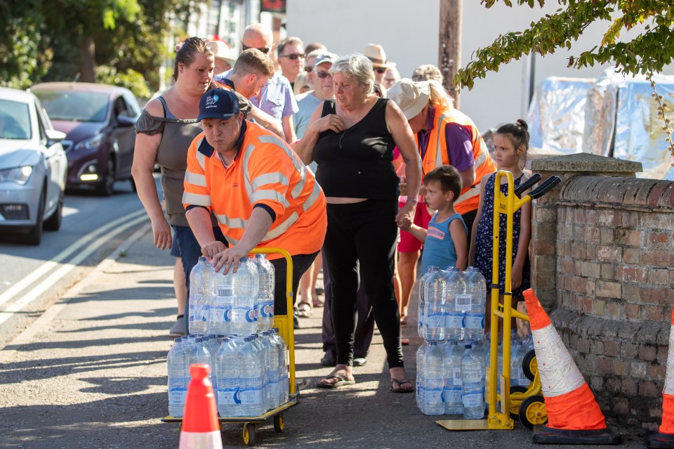 Residents pictured queuing for water bottles in Haddenham in Cambridgeshire this week