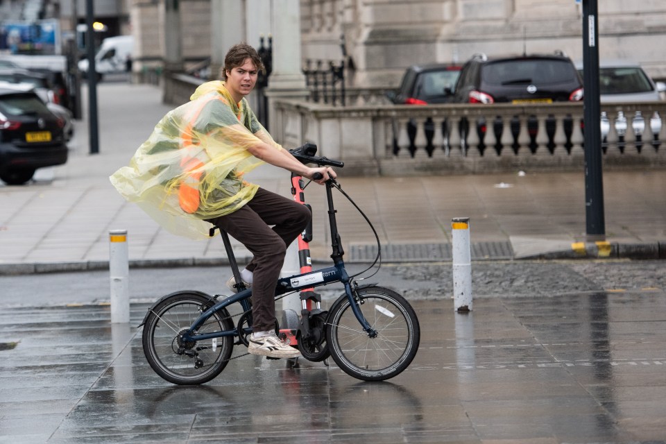 A cyclist splashes through the rain