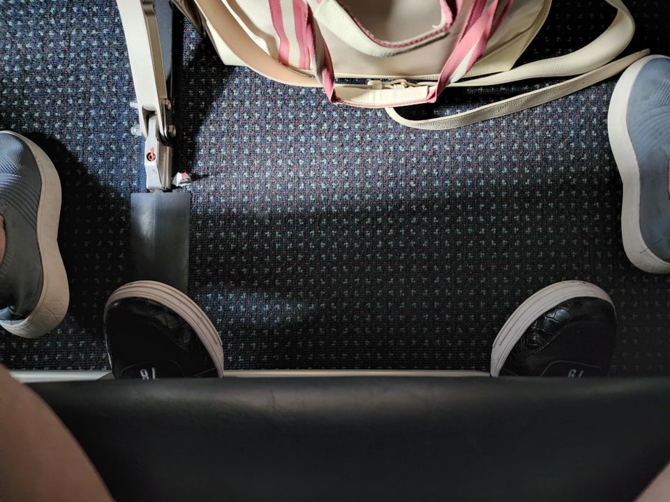 The passenger behind's feet were poking out beneath the woman's seat