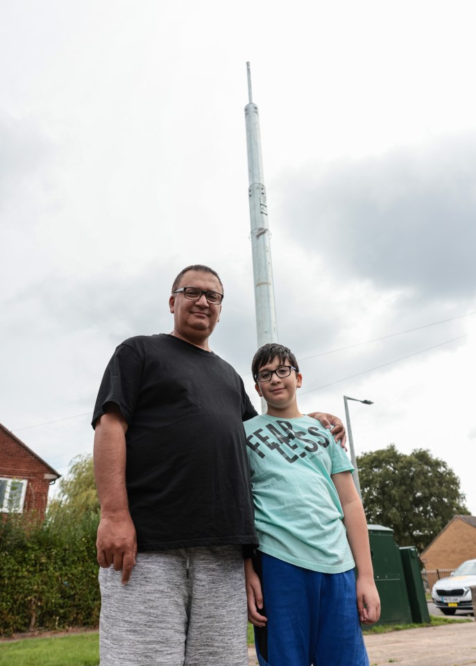 Abdul Khan and his son Rahim, pictured in front of the 6G phone mast on Lymm Walk in Cheadle, Stockport, Greater Manchester