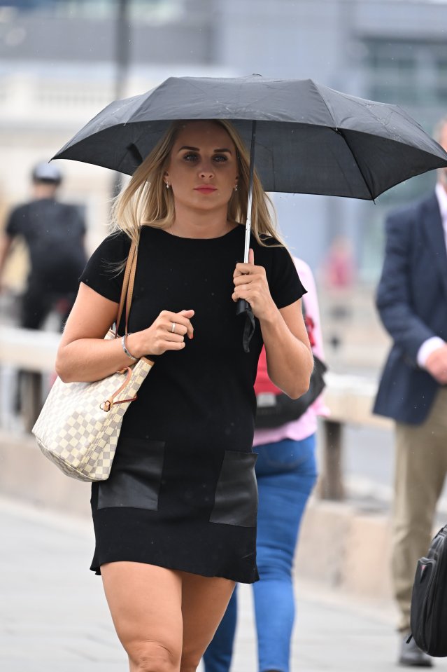 A commuter is seen walking in the rain near London Bridge