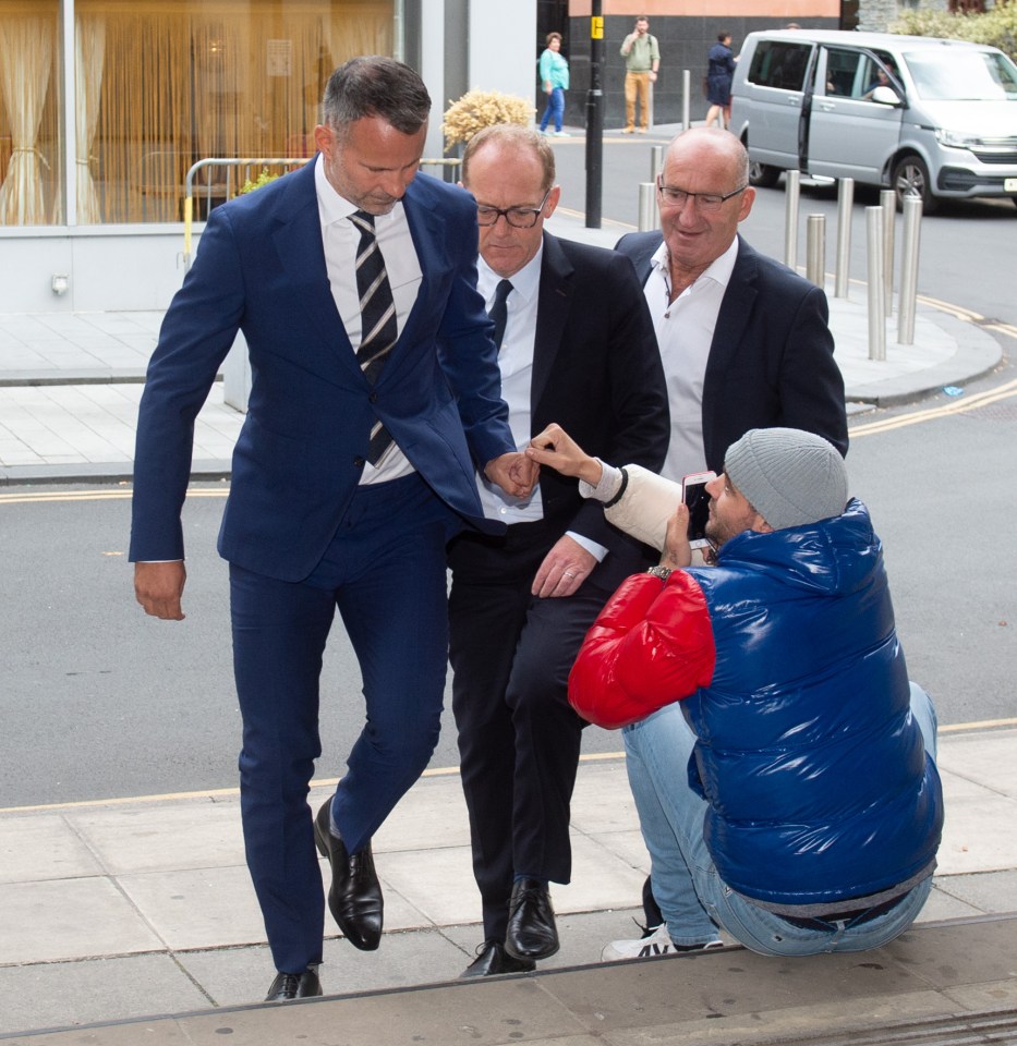 Ryan Giggs fist bumps a fan as he walks into Manchester Crown Court