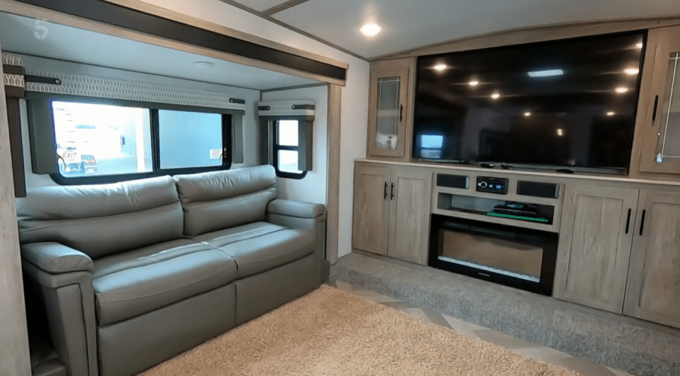 Inside an extraordinary lounge - complete with a satellite TV and fireplace - extends outwards to treble the size of the trailer