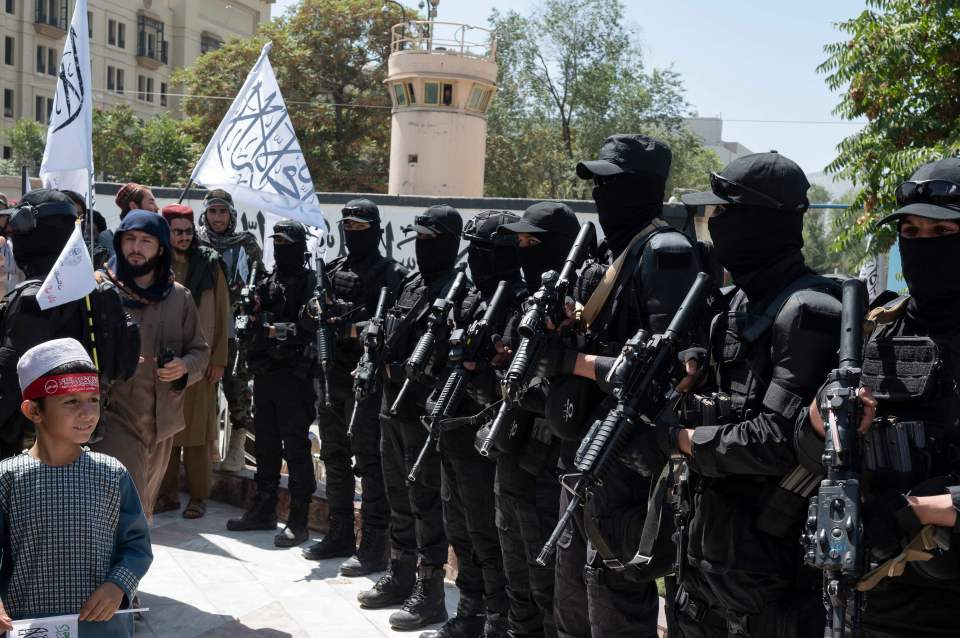 Armed Taliban fighters stand in formation at the Ahmad Shah Massoud square