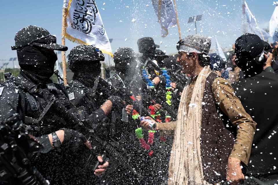 Taliban supporters celebrate next to Taliban fighters in Kabul