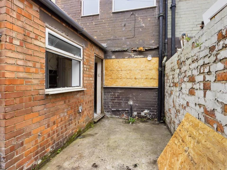 The kitchen window is boarded-up