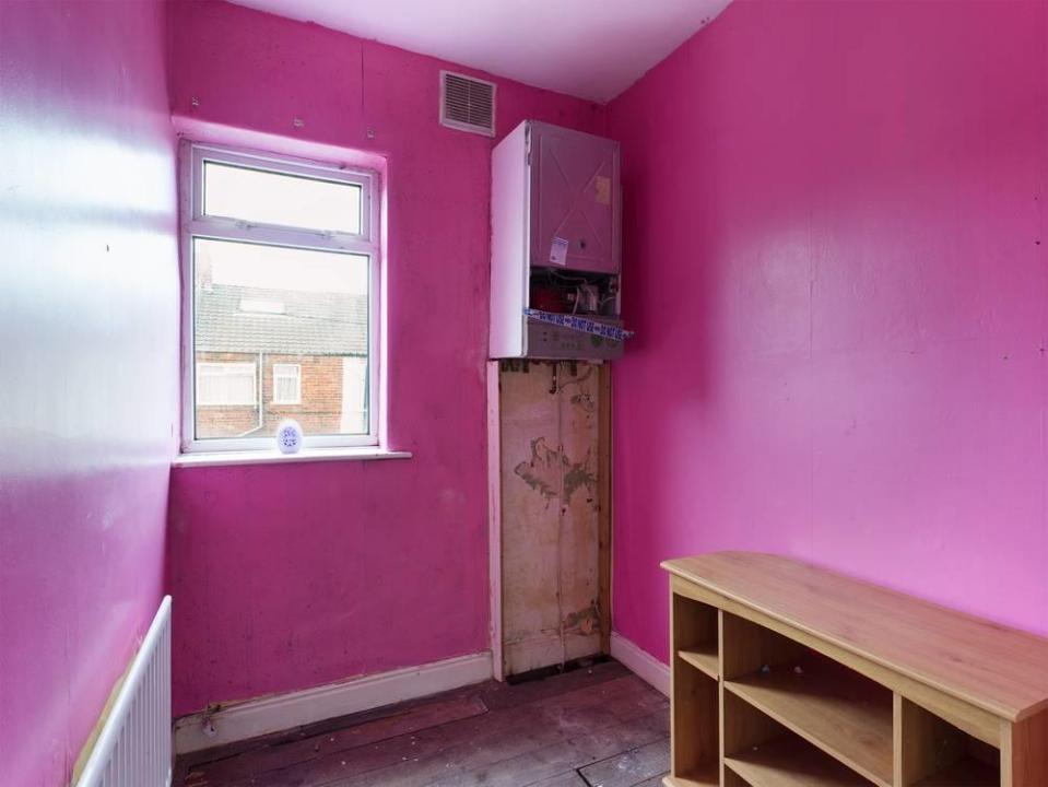 The smallest bedroom is bright pink and the boiler looks like it needs replacing