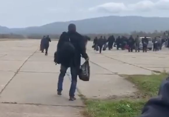 Another staggers as he walks towards a waiting bus