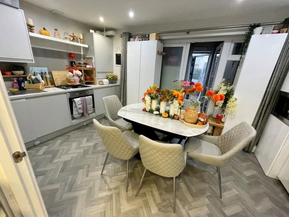 The property's kitchen decorated with white appliances and furnishings