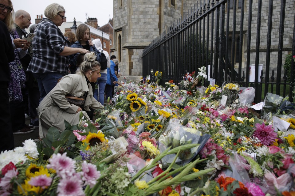 Well-wishers add to the mountains of bouquets outside Windsor Castle