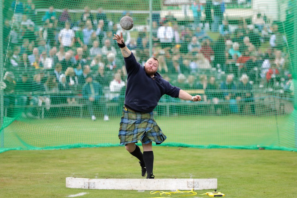 A participant competes in the shot put during the Braemar Highland Gathering at the Princess Royal & Duke of Fife Memorial Park