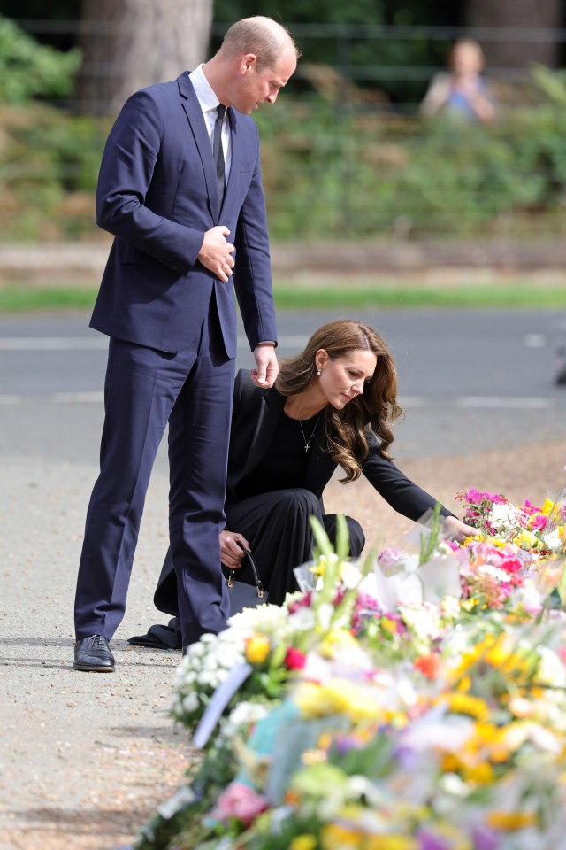 The couple looking at more of the thousands of tributes left for the Queen