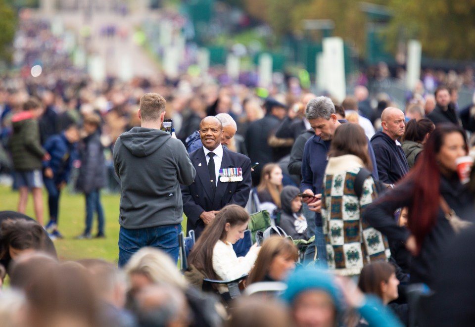 The long walk to Windsor Castle filled with people standing and sitting on camping chairs