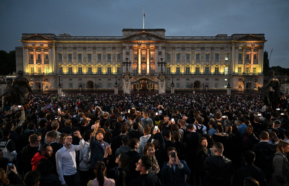 Buckingham Palace was lit up as the crowd gathered braved the rain