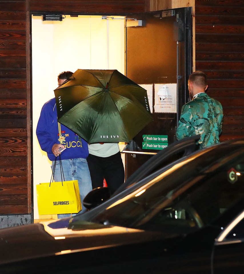 Grealish wore a blue Gucci sweater and carried a Selfridges bag in through a back entrance