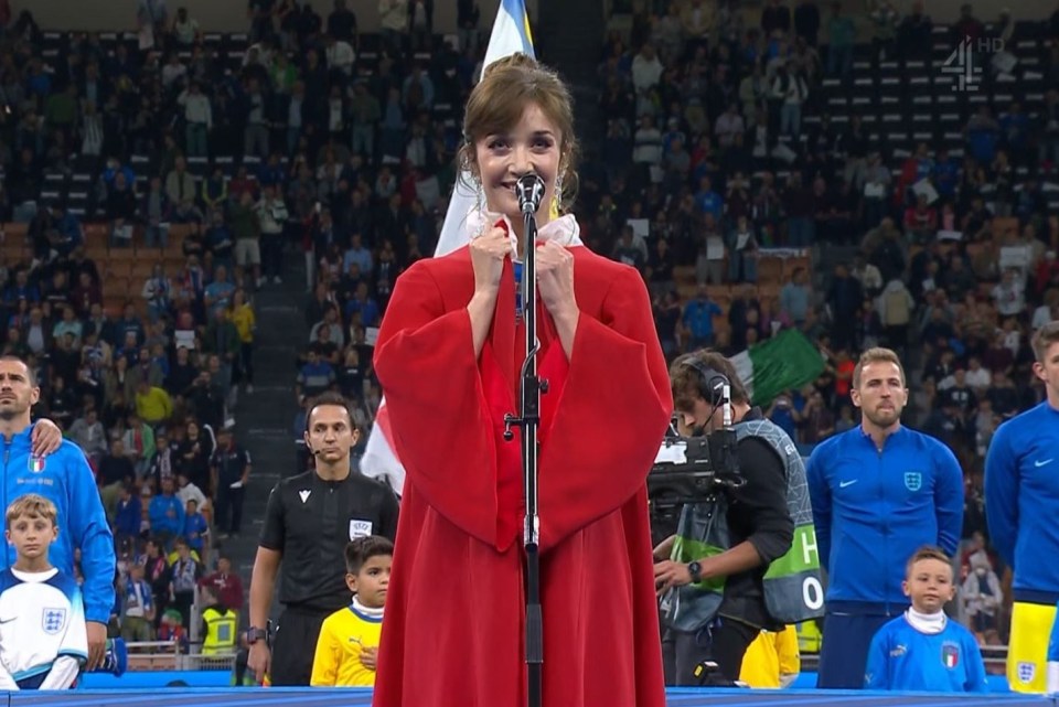 Carly Paoli wore a red cloak as she sang God Save the King