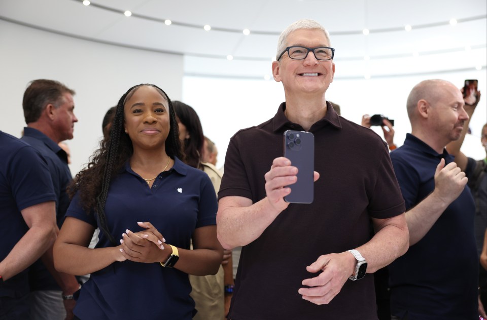 Apple CEO Tim Cook holds up a new iPhone 14 at the launch