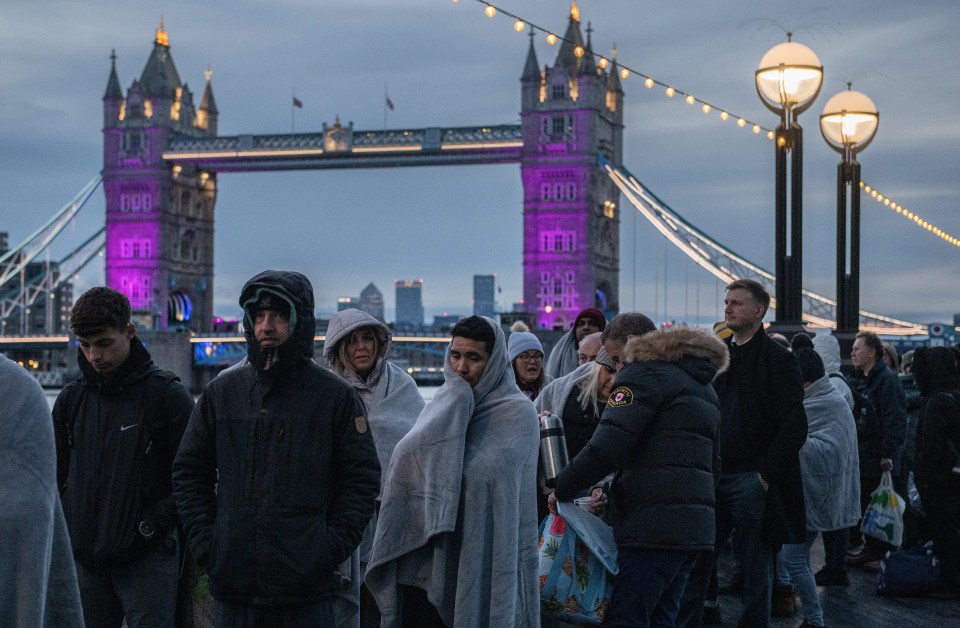 Crowds wrap up in blankets and warm hooded jackets as temperatures fall