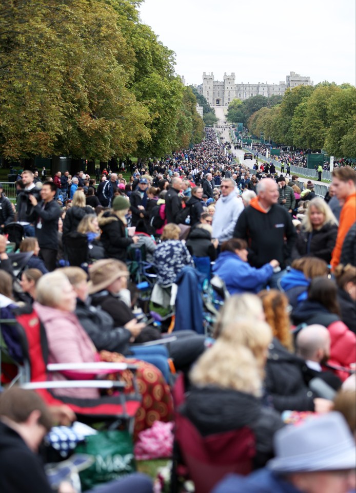 Mourners are sat waiting on camp chairs with blankets