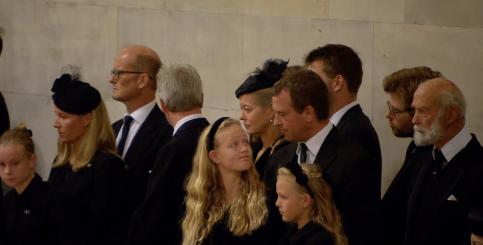 She gave her father a sombre smile as she stood alongside her younger sister Isla