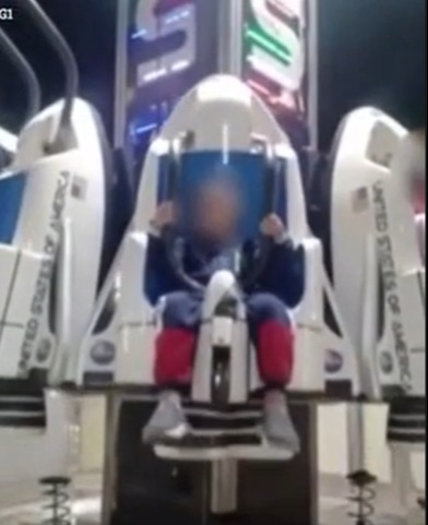 A young boy can be seen strapped in the ride's seat