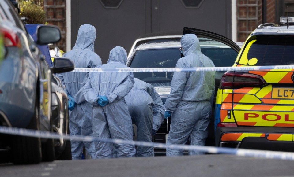 Scene of crime officers examine the aftermath of the shooting