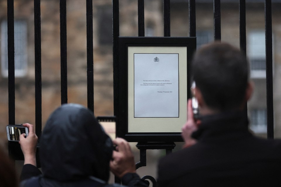 An announcement of the death of Queen Elizabeth is seen on a fence outside the Palace of Holyroodhouse, in Holyrood, Edinburgh