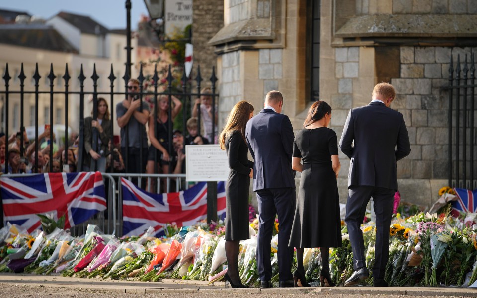 The couples spent time looking a floral tributes left in the Queen's memory