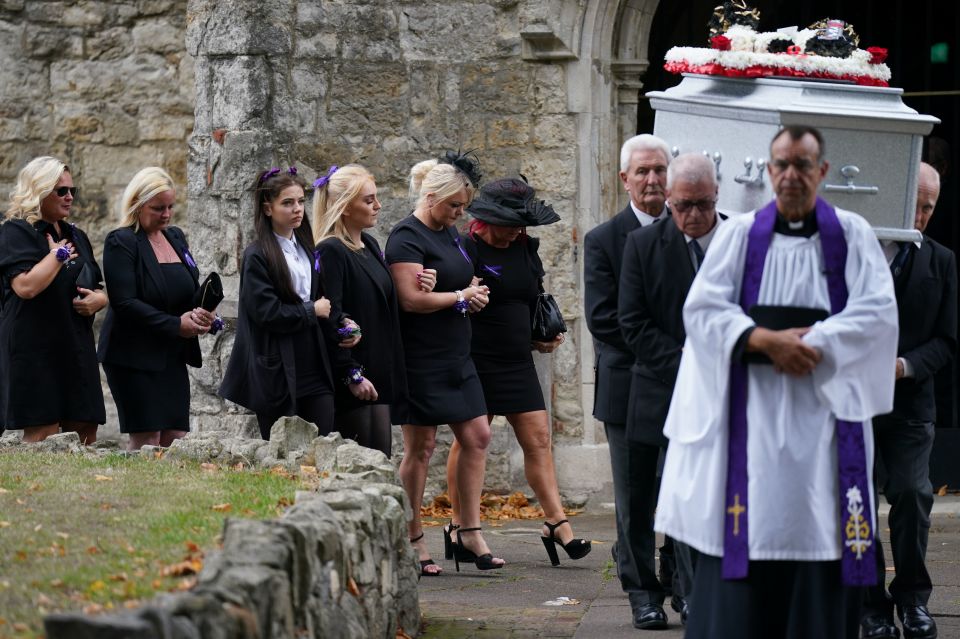 In the arms of friends, Hollie Dance leaves the service as her son is carried out the church