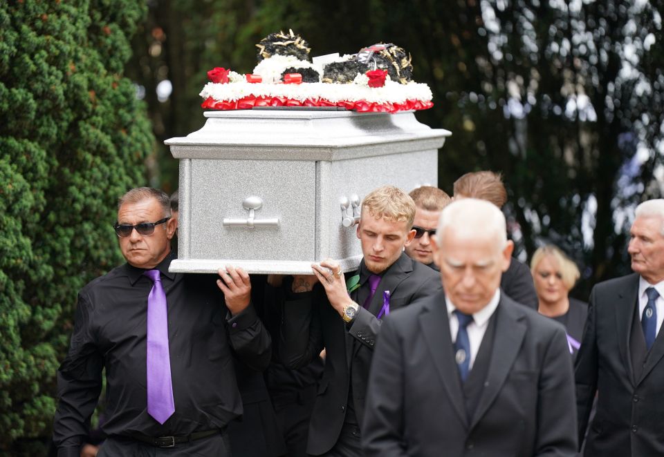 Archie's silver coffin is carried by pallbearers into the church