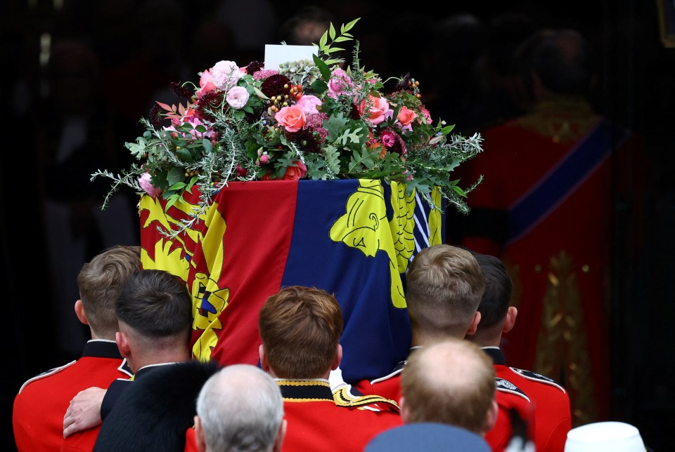 The coffin with the State Imperial Crown, Orb and Sceptre atop the Royal Standard is taken up the steps into Westminster Abbey