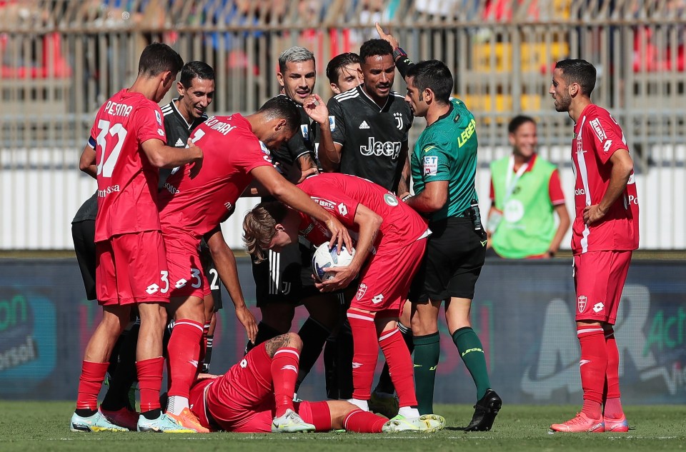 Monza players surround the afflicted Fabio Maresca as he lies hurt following the elbow