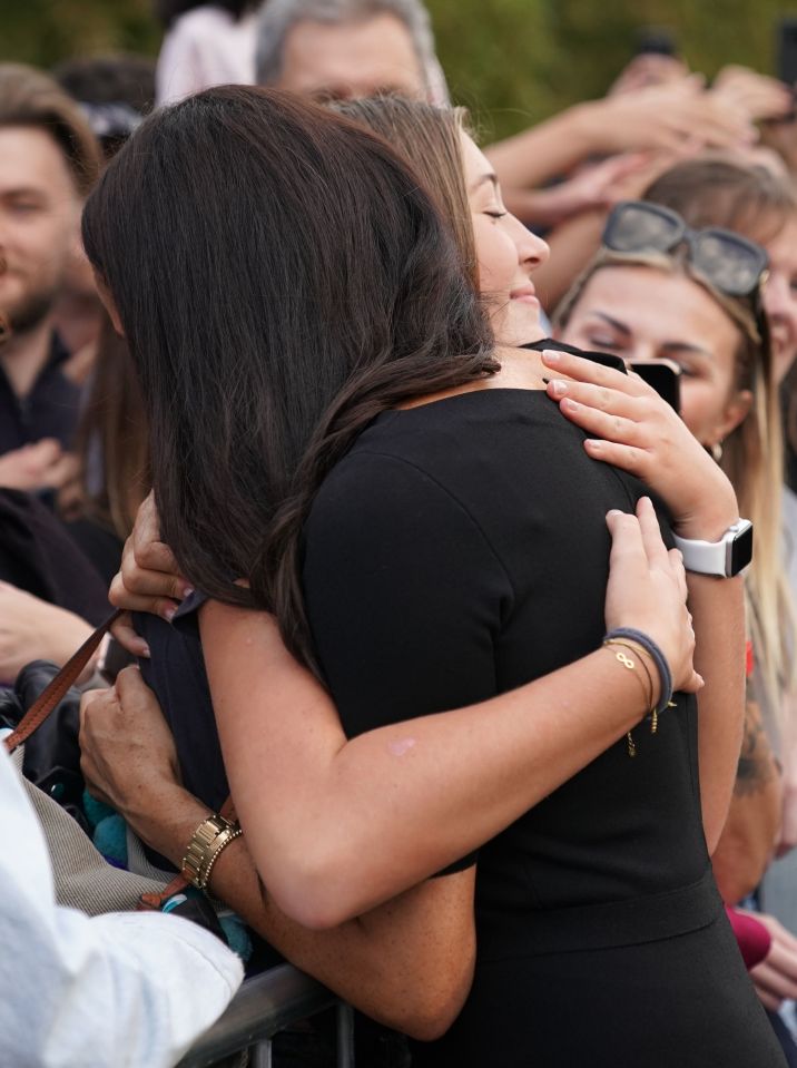 Meghan receives a hug from a member of the public