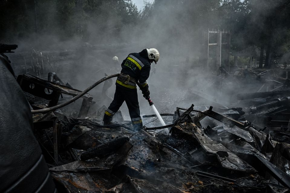 Firefighters douse the rubble of a restaurant destroyed by a missile strike in Kharkiv