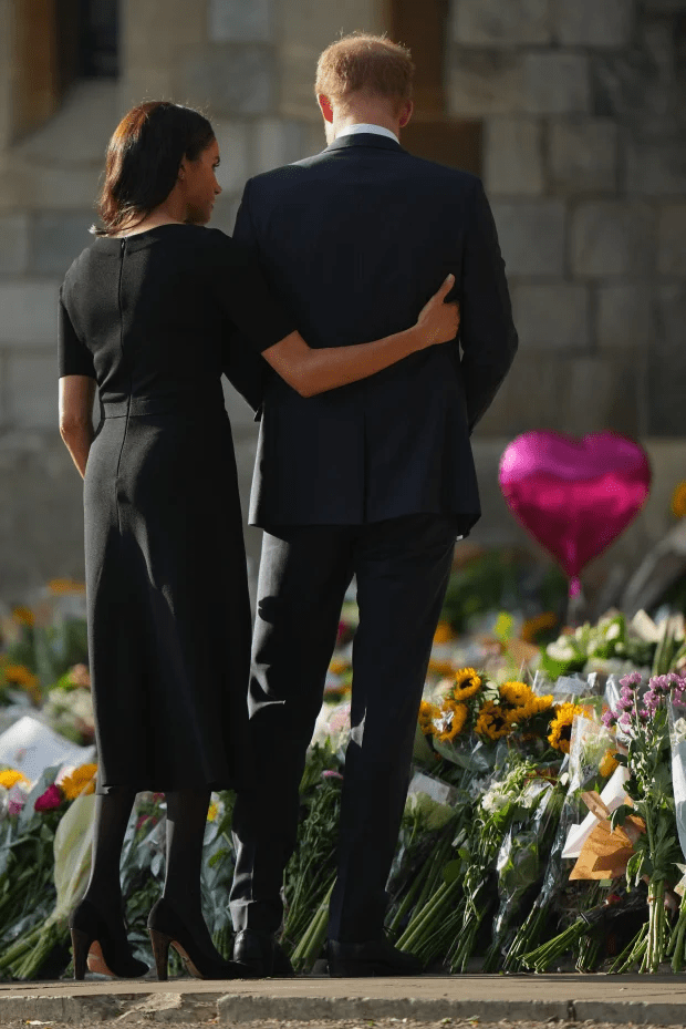 Meghan comforted her husband as they looked at tributes