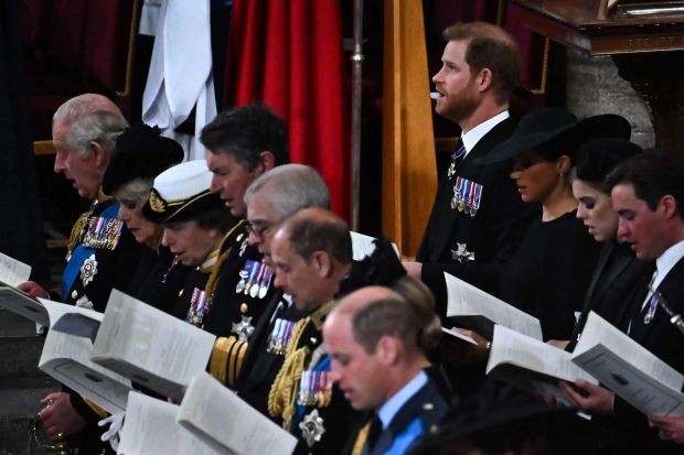 Prince Harry and Meghan Markle sat behind King Charles and Camilla