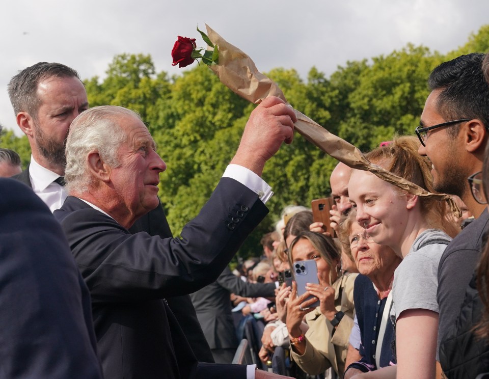 King Charles receives a rose from one well-wisher