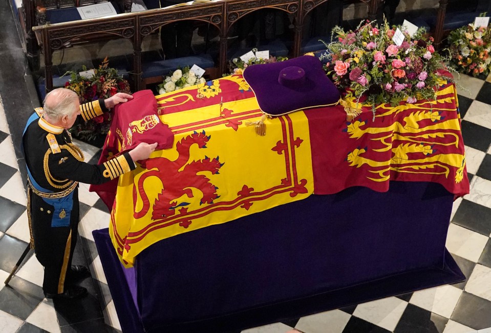 King Charles places the Queen’s Company Camp Colour of the Grenadier Guards on her coffin